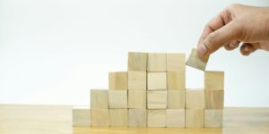 Une personne réalise un assemblage de cubes en bois